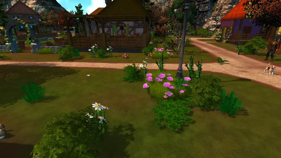 A village green in daylight. A timber-framed pavilion and a purple house with an orange roof stand beyond a path, with pink and white flowers and shrubs in front. A character in a brown coat walks a small dog on the path at the right edge.